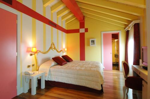 a bedroom with a bed with yellow and red stripes at Hotel Cà Zusto Venezia in Venice