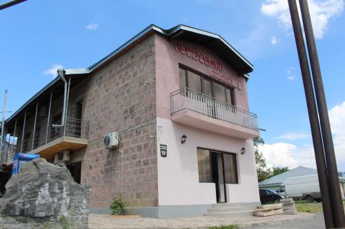 a pink and white building with a balcony at Hotel Rabati in Akhaltsikhe