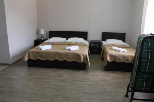 two beds in a hotel room with towels on them at Hotel Rabati in Akhaltsikhe