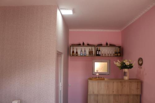 a room with pink walls and a shelf with bottles at Hotel Rabati in Akhaltsikhe