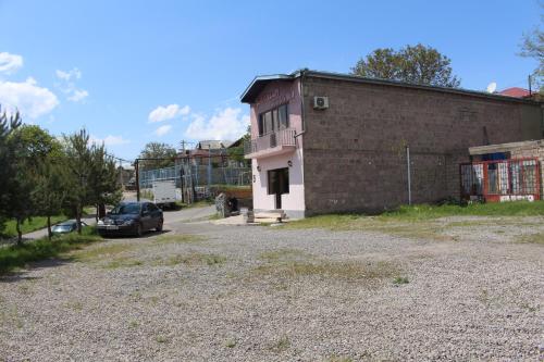 a car parked in front of a brick building at Hotel Rabati in Akhaltsikhe