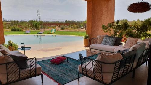 sala de estar con sofá y piscina en Loop - An hedonist house, en Tameslouht