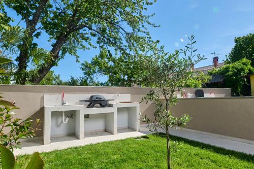 a garden with a white table on a fence at Apartments Dolcea in Umag