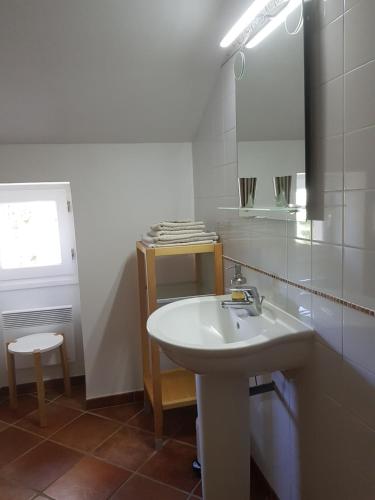 a bathroom with a sink and a mirror and a stool at Domaine de Valle in Sorbo-Ocagnano