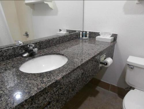y baño con lavabo y aseo. en Quality Inn & Suites Kansas City I-435N Near Sports Complex en Kansas City
