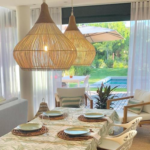 a dining room with a table with chairs and umbrellas at Vill'Amar Tróia in Troia