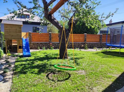 a tree in a yard with a green ring around it at Apartmány Karolin in Uhorská Ves