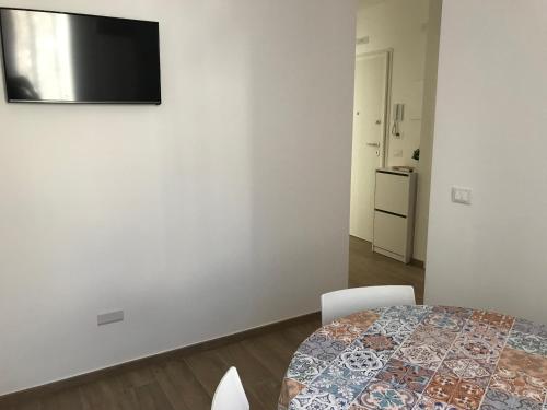 a white room with a table and a television on a wall at Chioggia House di Davide in Chioggia