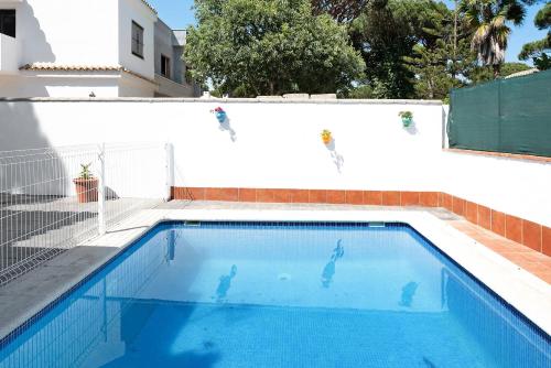 a swimming pool in front of a white wall at Poniente in Roche