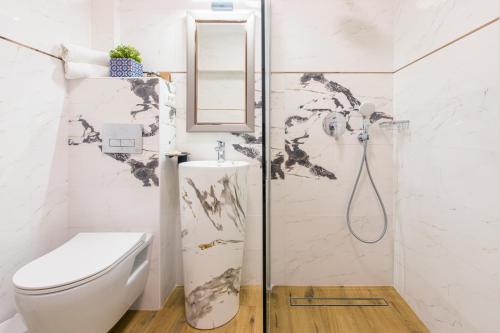 a white bathroom with a toilet and a shower at Pool House Mamaia in Mamaia Nord