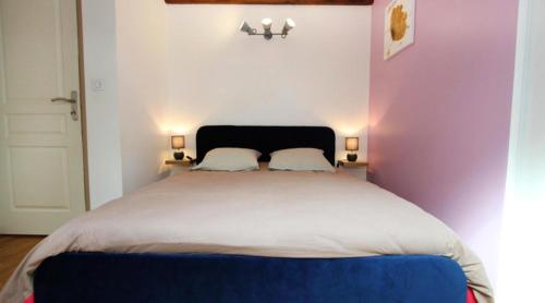 um quarto com uma cama grande e 2 almofadas em Villa de 5 chambres avec piscine privee jardin amenage et wifi a Divajeu em Divajeu