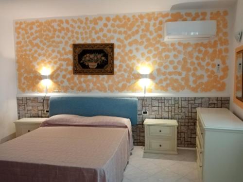 a bedroom with two beds and lights on the wall at Appartamento di villa gesualda in Serrara Fontana