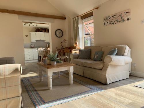 勞斯的住宿－Bramble cottage at Waingrove Farm，客厅配有沙发和桌子