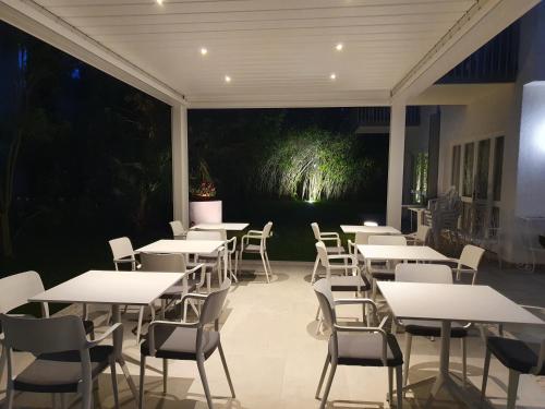 eine Gruppe von Tischen und Stühlen auf einer Terrasse in der Unterkunft Hotel Eurovil Garni in Lignano Sabbiadoro