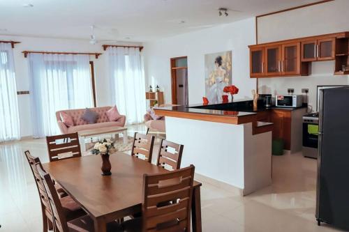 a kitchen and living room with a wooden table and a kitchen and a dining room at Breathtaking 3 bedroom fully furnished villa in Mombasa