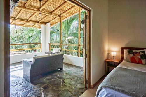 a bedroom with a bed and a large window at Villa Ananda in Mal País