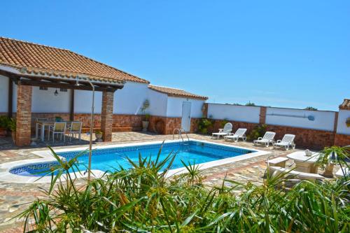 een villa met een zwembad en een patio bij La Esperanza in Medina Sidonia
