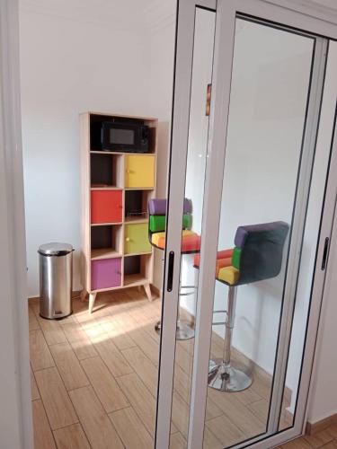 a sliding glass door with a table and a chair at Comme chez soi 2 in Tchimbanmba
