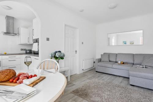 a kitchen and living room with a table with a plate of food at Little Place in Torquay
