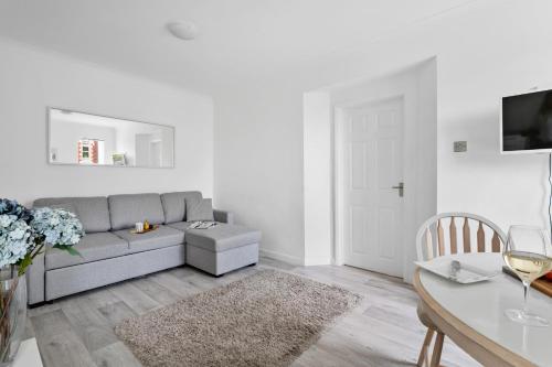 a living room with a gray couch and a table at Little Place in Torquay