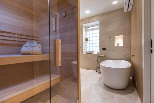 uma casa de banho com uma banheira e um chuveiro em vidro. em Adora Luxury Apartment em Split