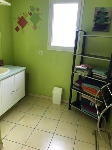 a bathroom with a sink and a shelf with towels at Belle Maison au calme 4 à 6 pers. 25mn Futuroscope in Vivonne