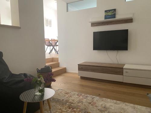 a living room with a flat screen tv on a wall at Adria Villa Apartment family and friends in Velden am Wörthersee