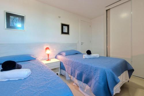 2 camas en una habitación con sábanas azules en Breezes Do Cumbuco #404 - Na Praia por carpediem, en Cumbuco