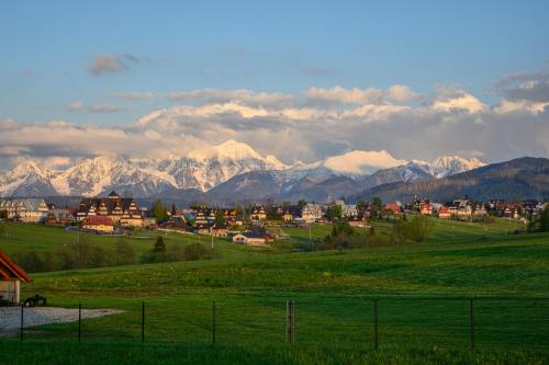 Eine Stadt auf einem Feld mit Bergen im Hintergrund in der Unterkunft Apartamenty ROZETA Poronin in Poronin