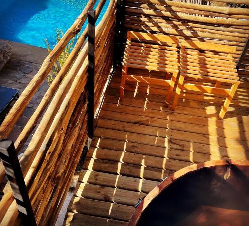 a wooden deck with a chair and a swimming pool at Hotel El Milagro in Pisco Elqui