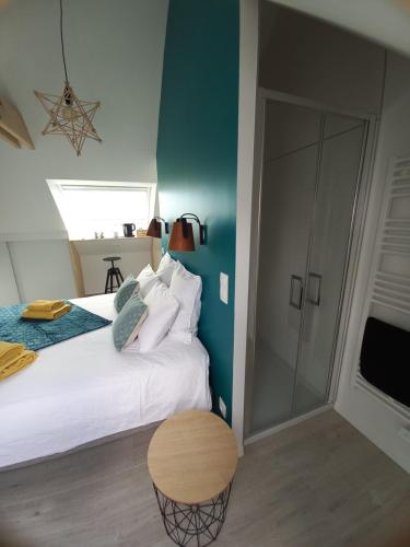 een slaapkamer met een wit bed en een blauwe muur bij Chambre d'hôtel tout confort au Pays des Abers in Plouguerneau