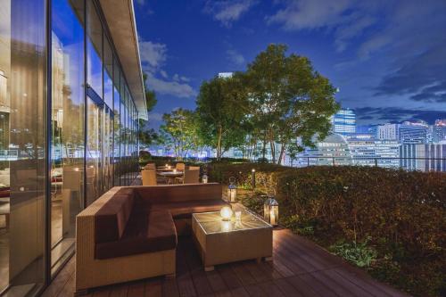 a rooftop patio with a view of the city at night at Harmonie Embrassee in Osaka