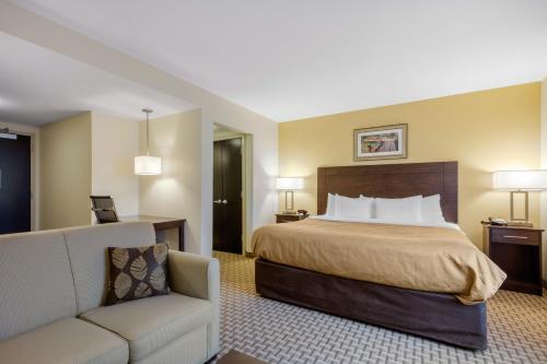 a hotel room with a bed and a couch at MainStay Suites St Louis Airport in Bridgeton