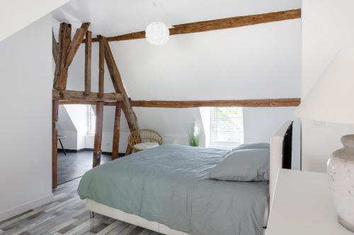 Schlafzimmer mit einem Bett und Holzbalken in der Unterkunft Un petit coin de Cathédrale in Beauvais