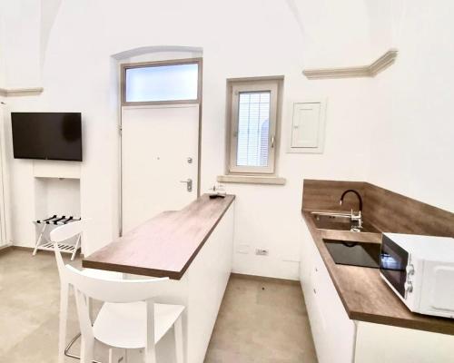 a kitchen with a wooden counter top and a sink at Teorema Suites in Nardò