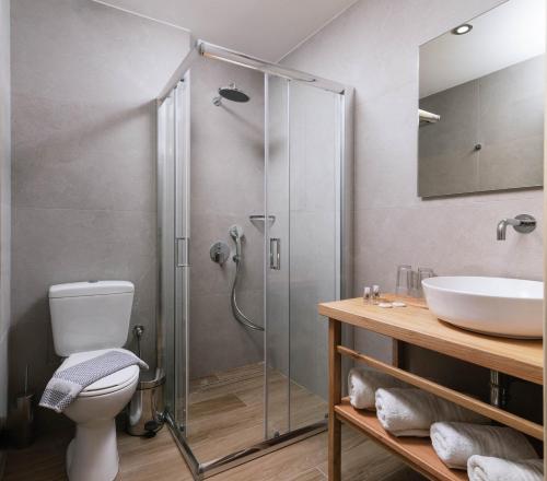 a bathroom with a shower and a toilet and a sink at Matala Bay Hotel & Apartments in Matala