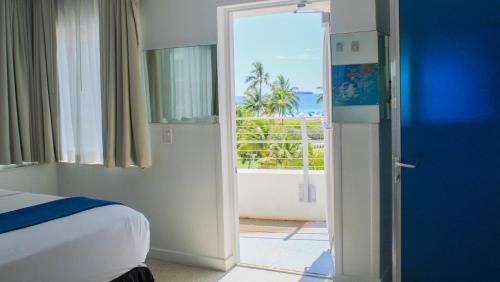 a bedroom with a bed and a door leading to a balcony at Clevelander Hotel in Miami Beach
