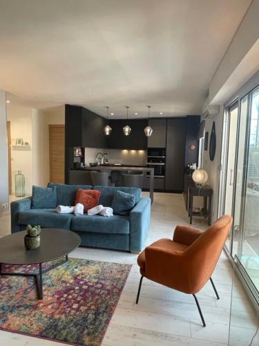 un salon avec un canapé bleu et une table dans l'établissement Deux pièces spacieux Place de Gaulle centre-ville d'Antibes avec extérieur, à Antibes