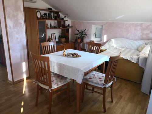 una sala da pranzo con tavolo, sedie e letto di Appartment Štajon a Izola