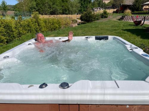 a man in a jacuzzi in a yard at Statek U Dubu in Svojetín