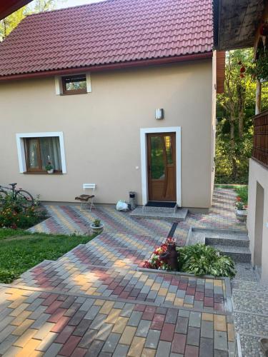 a house with a brick walkway leading to a door at Котедж in Podobovets