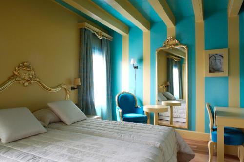 a bedroom with a bed and a table and a mirror at Hotel Cà Zusto Venezia in Venice