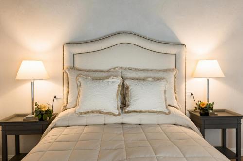 a bedroom with a white bed with two lamps at CORTE SAGGIN Charme Relais in San Pietro in Cariano