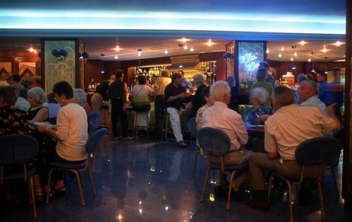 a group of people sitting at tables in a bar at Hotel Santa Lucia Le Sabbie d'Oro in Cefalù