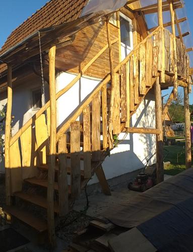 a wooden house with a porch and a swing at Casa Miliza - Agropensiunea şi Punctul Gastronomic Local, în vecinătatea castelului Salbek in Petriş