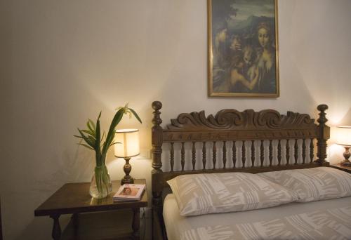 1 dormitorio con 1 cama y 1 mesa con lámpara en Appartamento Stibbert, en Florencia