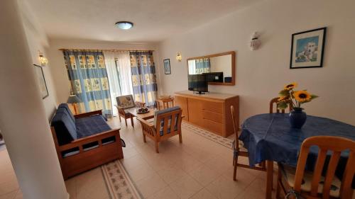 a living room with a table and a dining room at Meia Praia in Lagos