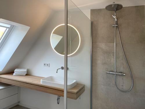 a bathroom with a shower with a sink and a mirror at Ferienwohnung Henny in Wyk auf Föhr