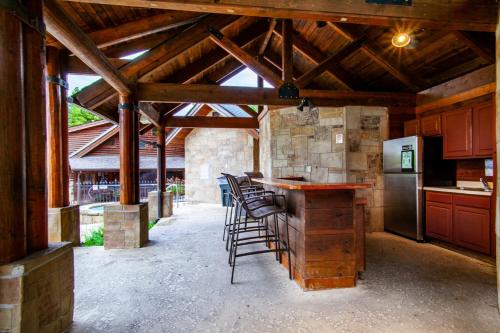 a kitchen with a bar with stools in a barn at Higher Ground Condo with Mountain and Golf View in Pigeon Forge
