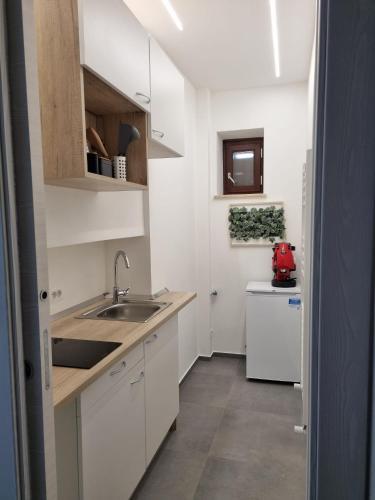 a small kitchen with white cabinets and a sink at VeraLuce in Caltavuturo